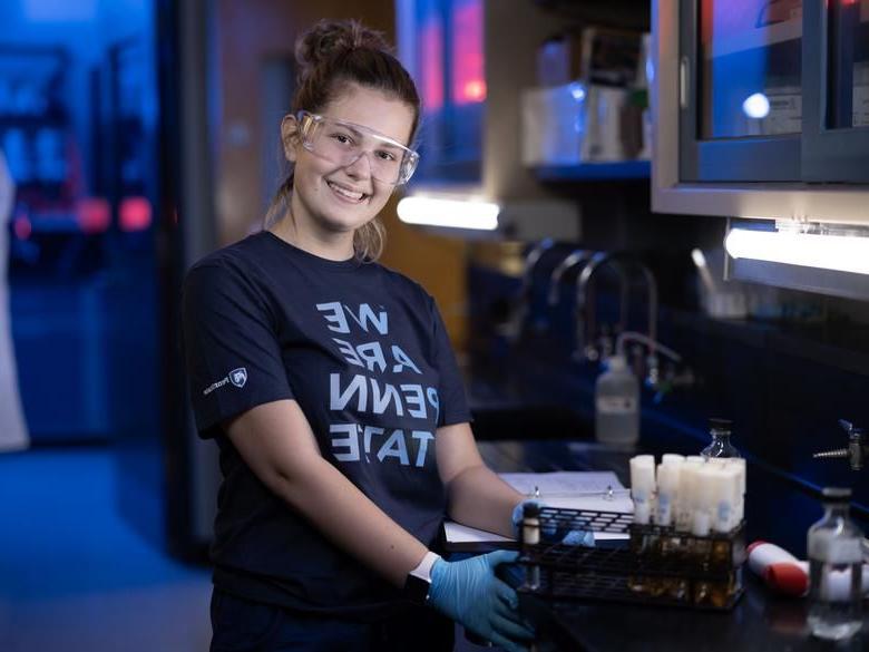 Student in lab smiling at camera